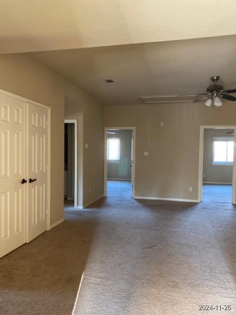 carpeted spare room featuring plenty of natural light and ceiling fan