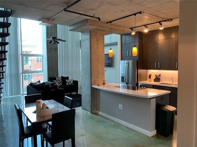 kitchen featuring black electric stovetop, ceiling fan, decorative light fixtures, stainless steel fridge with ice dispenser, and a breakfast bar area