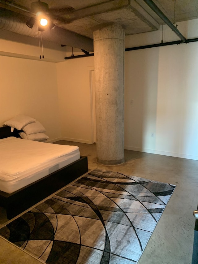 bedroom featuring decorative columns, ceiling fan, and concrete floors