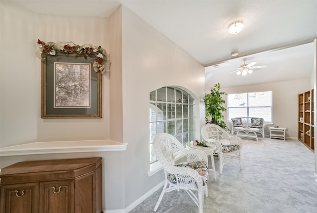 sitting room featuring ceiling fan, carpet floors, and vaulted ceiling