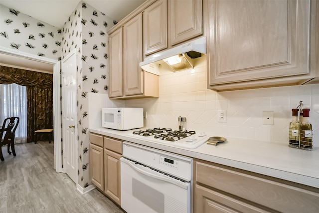 kitchen with backsplash, light brown cabinets, white appliances, and light hardwood / wood-style flooring