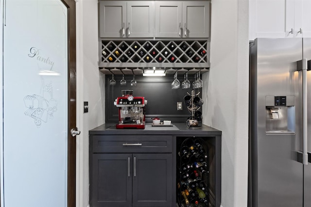 1617 Woodland Valley Dr, Huntsville, TX 77340 - bar with gray cabinetry, stainless steel fridge, and beverage cooler