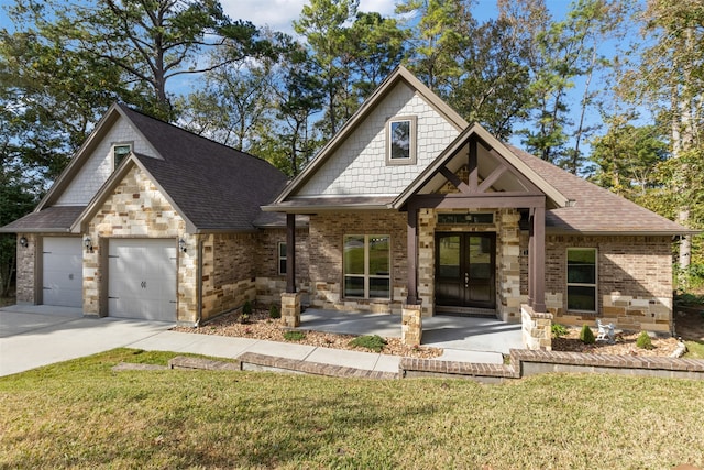 view of front of home featuring french doors, a front yard, and a garage