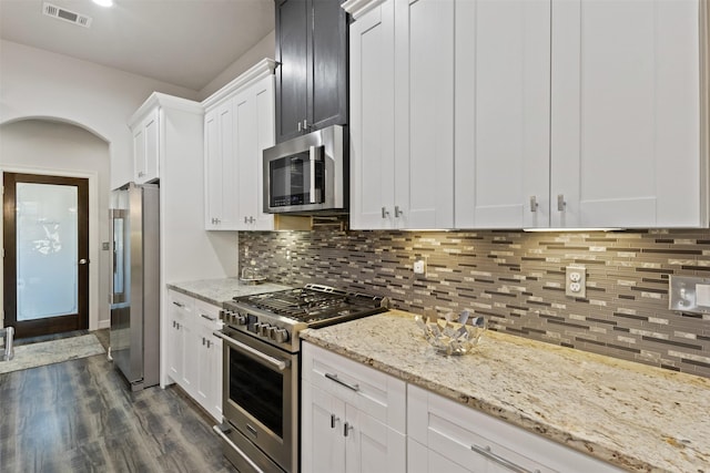 1617 Woodland Valley Dr, Huntsville, TX 77340 - kitchen with dark hardwood / wood-style flooring, tasteful backsplash, light stone counters, premium appliances, and white cabinetry