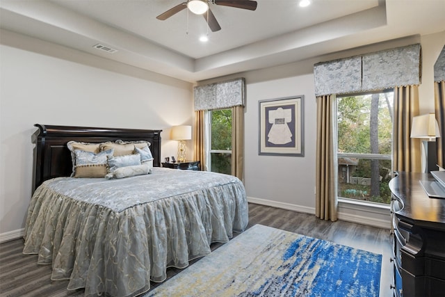 1617 Woodland Valley Dr, Huntsville, TX 77340 - bedroom featuring a raised ceiling, ceiling fan, dark hardwood / wood-style flooring, and multiple windows