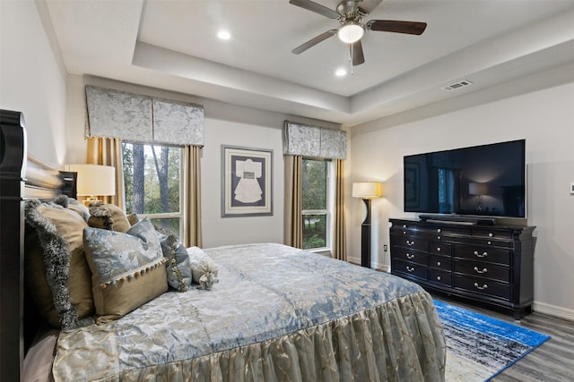 1617 Woodland Valley Dr, Huntsville, TX 77340 - bedroom featuring ceiling fan, dark hardwood / wood-style floors, a tray ceiling, and multiple windows