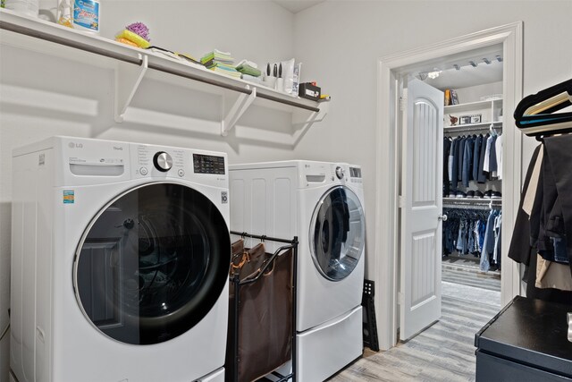 clothes washing area featuring washer and dryer and light hardwood / wood-style floors