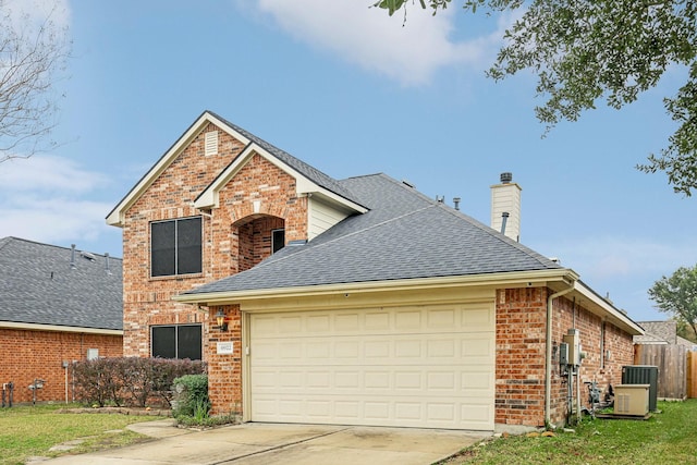 view of property featuring a garage and central AC unit