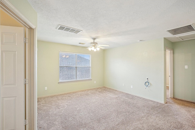 carpeted spare room featuring ceiling fan and a textured ceiling