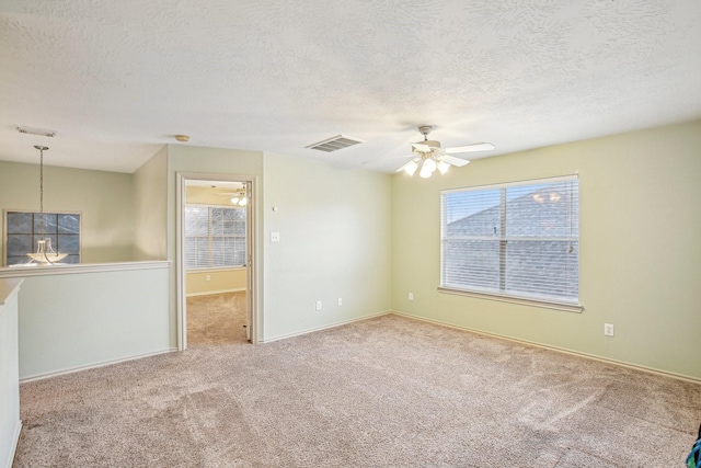 empty room featuring carpet flooring, a textured ceiling, and a wealth of natural light