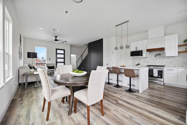 dining area with ceiling fan and light hardwood / wood-style flooring