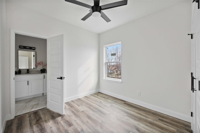 unfurnished bedroom featuring ceiling fan, sink, and light hardwood / wood-style floors