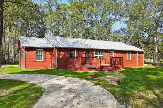 view of front of house with a wooden deck and a front lawn