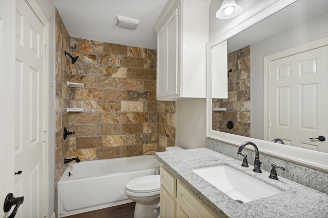 full bathroom with vanity, tiled shower / bath combo, hardwood / wood-style flooring, and toilet