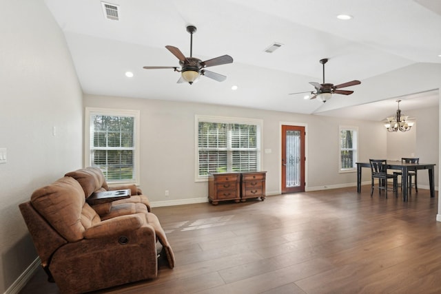 living room with ceiling fan with notable chandelier, dark wood-type flooring, and lofted ceiling