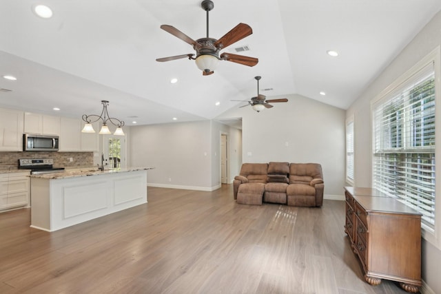 living room with light hardwood / wood-style flooring, ceiling fan, lofted ceiling, and sink