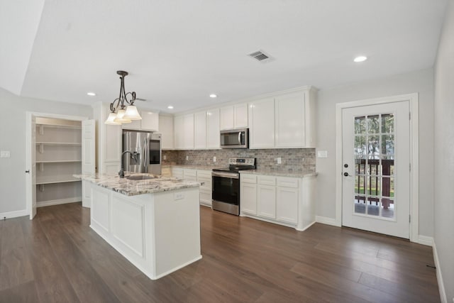 kitchen featuring white cabinets, hanging light fixtures, appliances with stainless steel finishes, and dark wood-type flooring