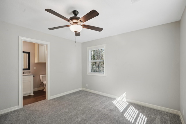 unfurnished bedroom with light colored carpet, ensuite bath, and ceiling fan