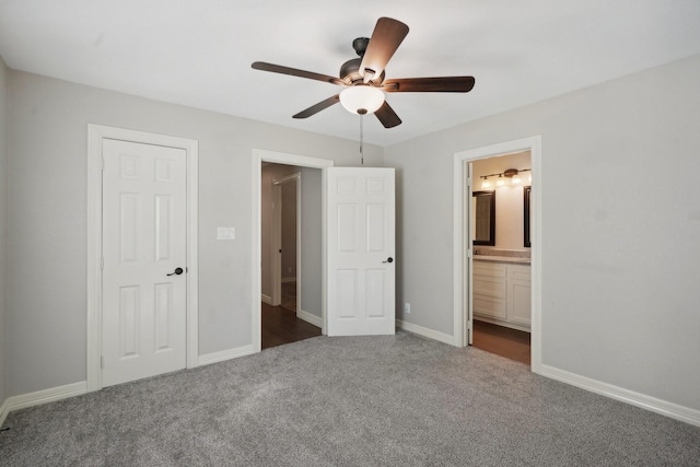 unfurnished bedroom with connected bathroom, ceiling fan, a closet, and dark carpet