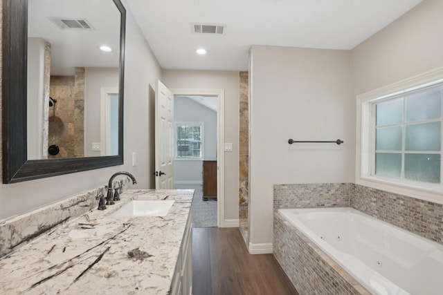 bathroom with vanity, wood-type flooring, and shower with separate bathtub