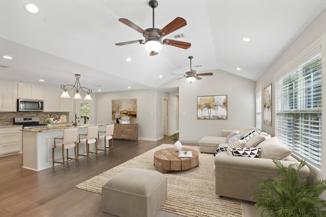 living room with ceiling fan, dark hardwood / wood-style floors, and lofted ceiling