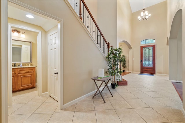 entryway featuring light tile patterned flooring, high vaulted ceiling, and an inviting chandelier