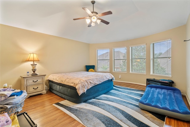 bedroom featuring multiple windows, ceiling fan, and light wood-type flooring