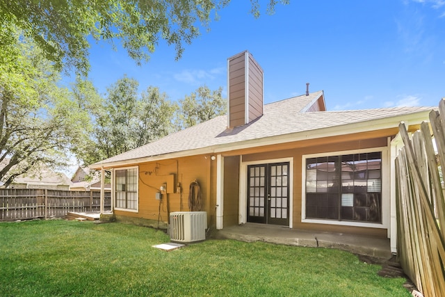 back of house with a lawn, cooling unit, and french doors