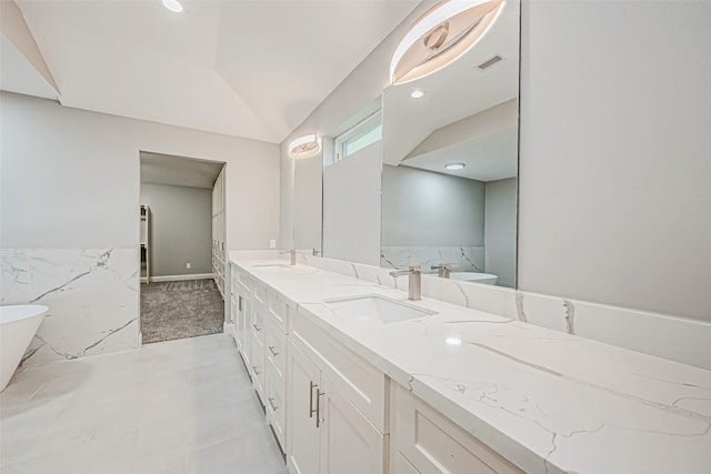 bathroom featuring tile patterned floors, vanity, a bathtub, and tile walls