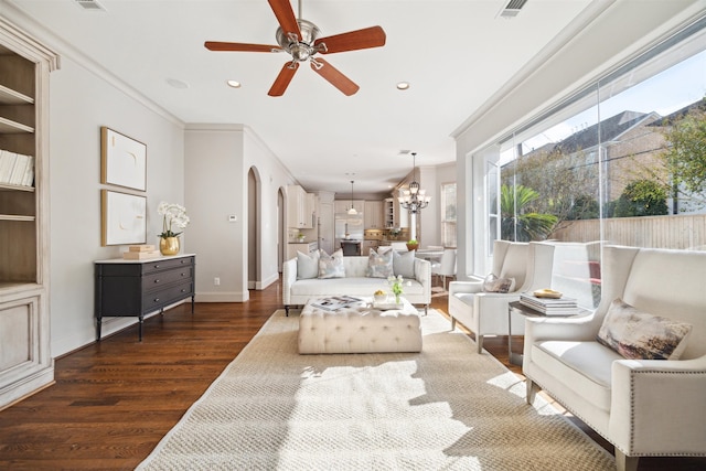 living room with dark hardwood / wood-style floors, ornamental molding, and ceiling fan with notable chandelier