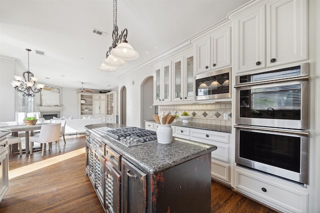 kitchen with backsplash, white cabinetry, and stainless steel appliances