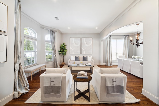 living room with ornamental molding, dark hardwood / wood-style floors, and a notable chandelier