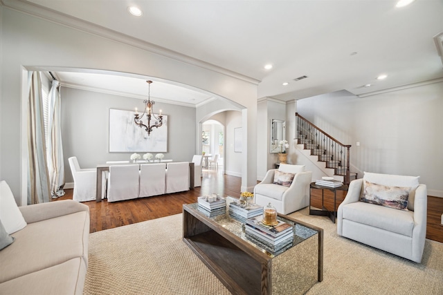 living room with crown molding, an inviting chandelier, and hardwood / wood-style flooring