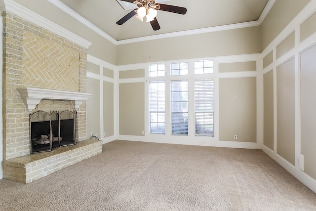 unfurnished living room with carpet, ceiling fan, crown molding, a fireplace, and a high ceiling