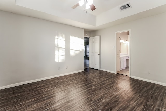 unfurnished bedroom with ensuite bathroom, dark hardwood / wood-style flooring, and ceiling fan with notable chandelier