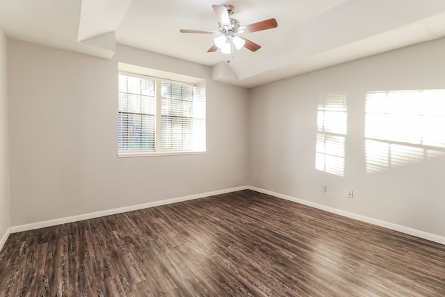 spare room with dark hardwood / wood-style flooring and ceiling fan