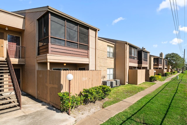 view of side of property featuring a lawn and central AC unit