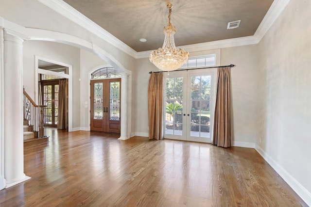 entryway with french doors, ornamental molding, a notable chandelier, and hardwood / wood-style flooring