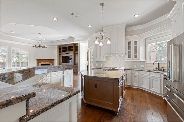 kitchen featuring pendant lighting, a center island, dark hardwood / wood-style flooring, and white cabinetry