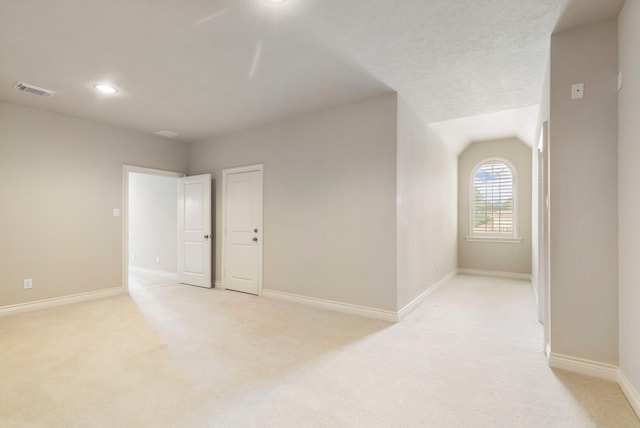 carpeted empty room featuring lofted ceiling