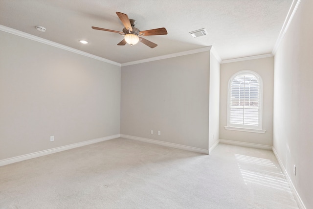 carpeted spare room with a textured ceiling, ceiling fan, and crown molding