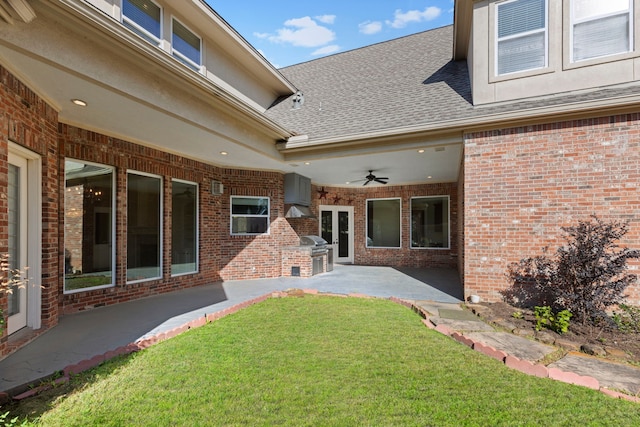 view of yard with a patio area, ceiling fan, and exterior kitchen