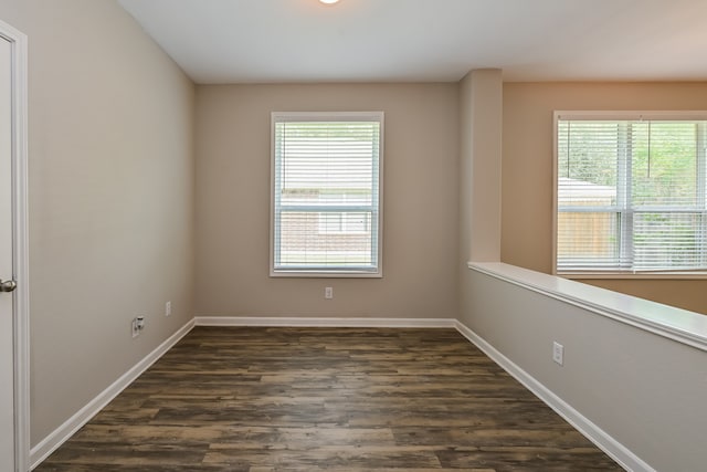 spare room with plenty of natural light and dark hardwood / wood-style floors