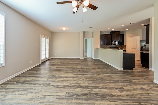 unfurnished living room featuring ceiling fan and dark hardwood / wood-style flooring