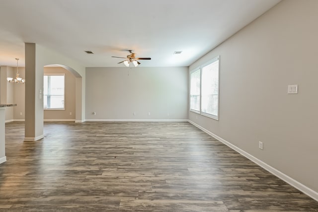 empty room featuring dark hardwood / wood-style flooring and ceiling fan with notable chandelier