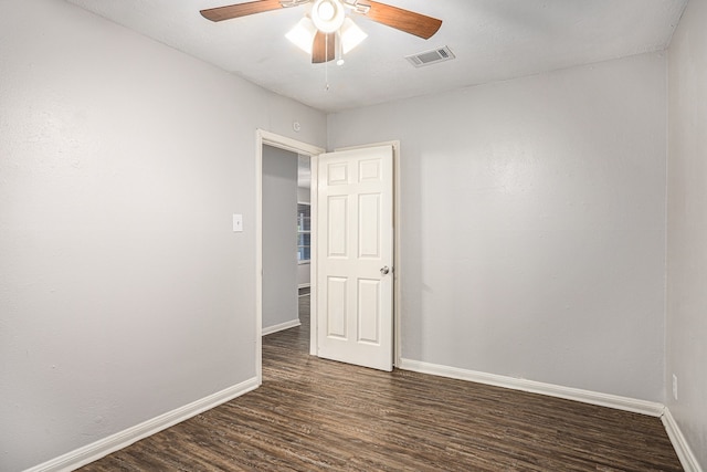 empty room featuring ceiling fan and dark wood-type flooring