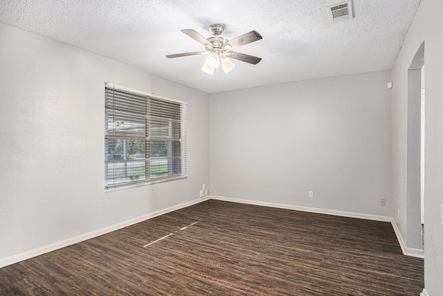 empty room featuring dark hardwood / wood-style floors, ceiling fan, and a textured ceiling