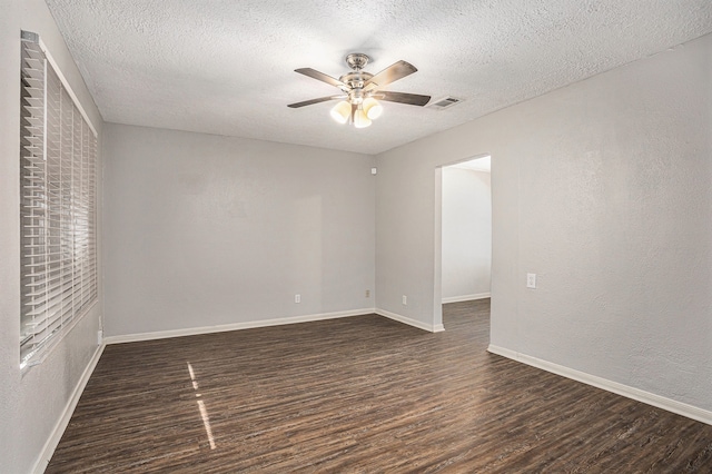 empty room with a textured ceiling, ceiling fan, and dark wood-type flooring