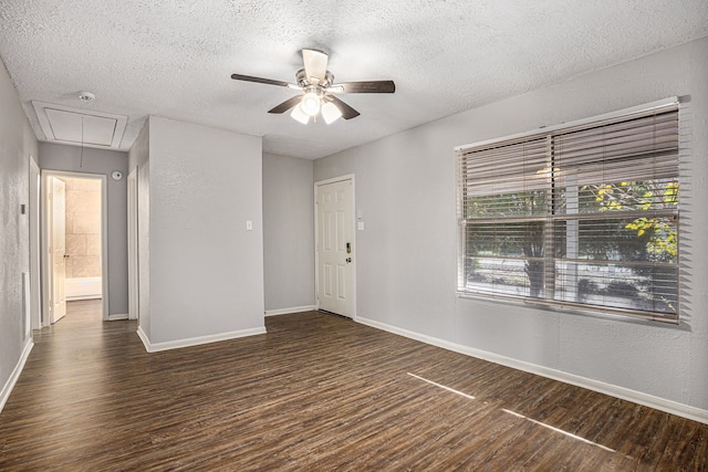 spare room featuring ceiling fan, dark wood-type flooring, and a textured ceiling