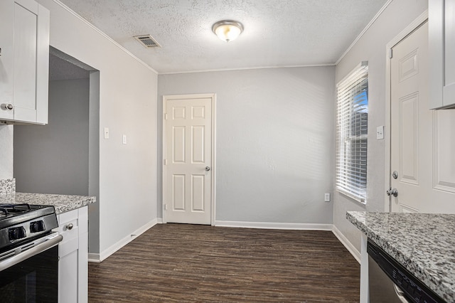 kitchen featuring white cabinetry, dark hardwood / wood-style flooring, stainless steel appliances, and a textured ceiling